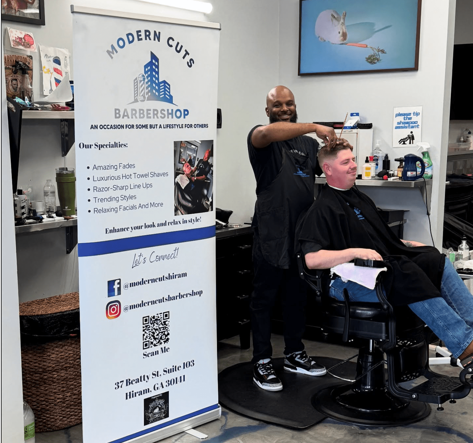 Barber cutting client's hair in modern shop.