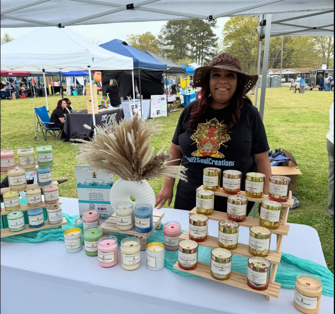 Woman selling candles at outdoor market stall.